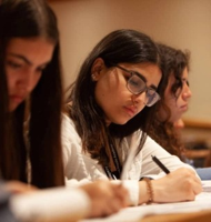 A focused student writing notes during a classroom session.