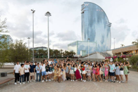 A group of young students posing for a photo outdoors in front of the W Barcelona hotel.