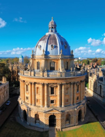 A historic university dome building under a clear blue sky on a university campus.
