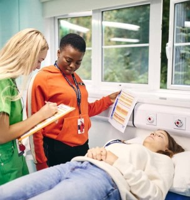 Students participating in a medical training activity with a patient simulator during a medicine programme in Cambridge.