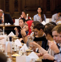 Students dining together inside a historic university dining hall during a summer programme.