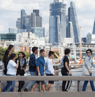 Students walking together through London with modern city buildings in the background.