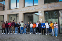 Group of students and staff standing outside the Škoda Auto educational center building during an academic or training visit.