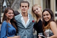A group of students smiling and celebrating together at a graduation event.